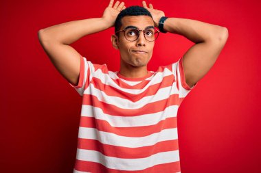 Genç, yakışıklı, Afro-Amerikan bir adam, günlük çizgili tişört ve gözlük takıyor, tavşan kulağı hareketi yapıyor, avuç içiyle alaycı ve şüpheci görünüyor. Paskalya tavşanı kavramı.