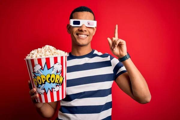 年轻英俊的非洲裔美国男人用3D眼镜看电影 一边吃爆米花 一边指指点点 想出了个好主意 又兴奋又快乐第一部分 — 图库照片