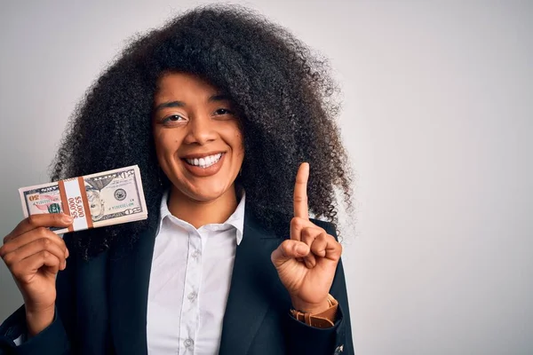 アフロの髪を持つ若いアフリカ系アメリカ人のビジネス女性は 幸せな顔をしたアイデアや質問を指差す指で驚きの現金ドル紙幣の束を保持し ナンバーワン — ストック写真