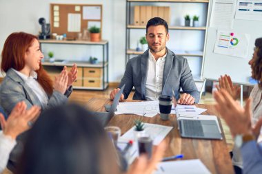 Group of business workers smiling happy and confident. Working together with smile on face applauding one of them at the office
