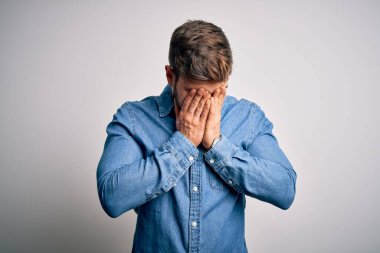 Sakallı, mavi gözlü, sıradan bir kot gömlek giyen, yorgunluk ve baş ağrısı için gözlerini ovuşturan, uykulu ve yorgun ifadeli yakışıklı sarışın bir adam. Görüş sorunu