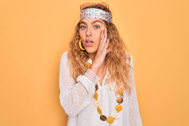 Mavi gözlü, güneş gözlüğü takan, aksesuar takan genç, güzel sarışın kadın gizli dedikodular söylüyor, kötü niyetli konuşmalar fısıldıyor.