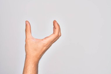 İzole edilmiş beyaz arka plan üzerinde parmaklarını gösteren beyaz bir adamın eli. Görünmez bir şeyi alıp, parmaklarıyla uzayı gösteren bir nesneyi tutuyor.