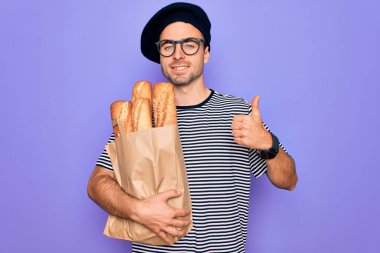 Mavi gözlü genç fırıncı Fransız beresi takıyor. Yanında ekmek var. Gülümsüyor, mutlu.