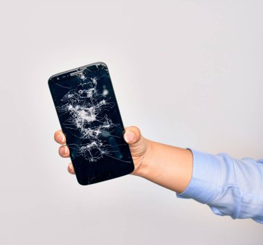 Kırık akıllı telefon tutan beyaz arka planda beyaz ekran görüntüsü olan beyaz bir kadının eli.