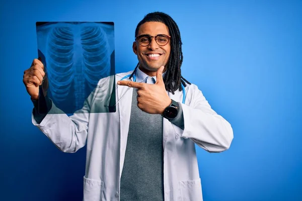 年轻的非洲裔美国医生 有可怕的头发 手持胸部肺X光 很高兴用手指头指指点点 — 图库照片
