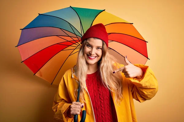 Young Beautiful Blonde Woman Wearing Raincoat Wool Cap Holding Colorful — Stock Photo, Image
