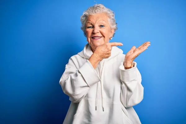 Senior Mooie Sportieve Vrouw Draagt Witte Sweater Geïsoleerde Blauwe Achtergrond — Stockfoto