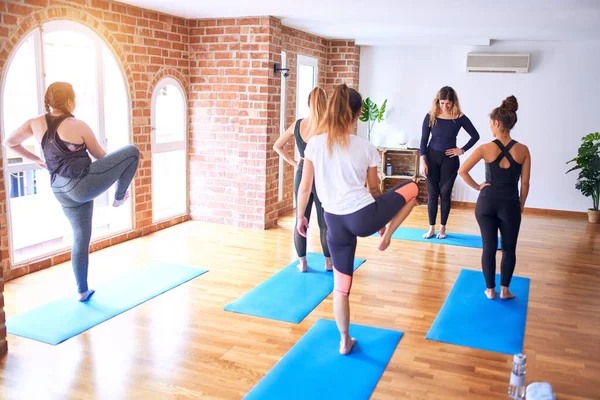 年轻美丽的一群女运动员正在练瑜伽 教练教学平衡在体育馆里对女运动员摆姿势 — 图库照片