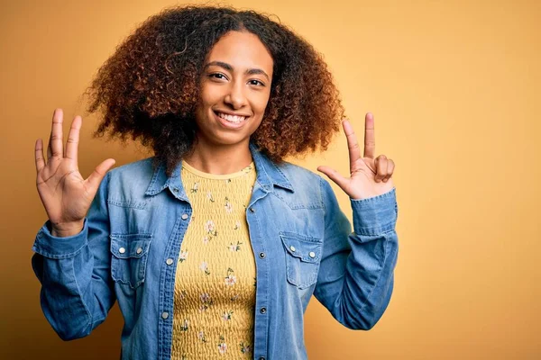 Молодая Африканская Американка Афроволосами Джинсовой Рубашке Жёлтом Фоне Показывает Показывает — стоковое фото