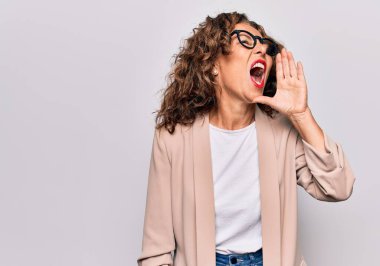 Orta yaşlı, güzel iş kadını gözlüklü, izole edilmiş beyaz arka planda durup el ele tutuşarak bağırıyor. İletişim konsepti.