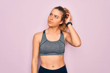 Genç, sarışın, mavi gözlü sporcu kadın spor kıyafetleri giyiyor ve soru soruyor. Şüpheyle kararsız, kafa kafaya düşünerek. Düşünceli kavram.