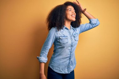 Afro saçlı, güzel, Afro saçlı, mutlu ve tebessüm eden genç bir Amerikalı kadın. Konsept aranıyor.