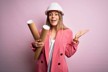 Genç, güzel, esmer, kasklı bir kadın elinde planlar, çok mutlu ve heyecanlı. Kazanan ifade zaferi büyük bir gülümsemeyle kutluyor ve ellerini kaldırıyor.