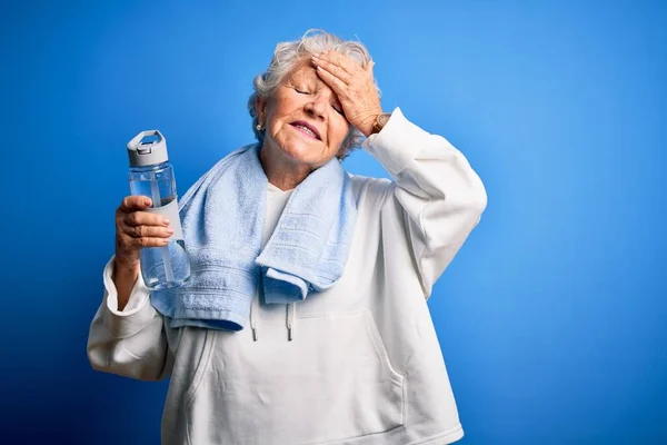 Senior Bela Mulher Desportiva Segurando Garrafa Água Sobre Fundo Azul — Fotografia de Stock