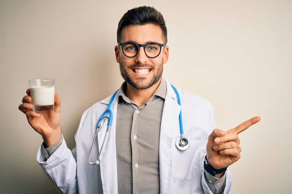 Joven Doctor Con Estetoscopio Sosteniendo Vaso Leche Sobre Fondo Aislado — Foto de Stock