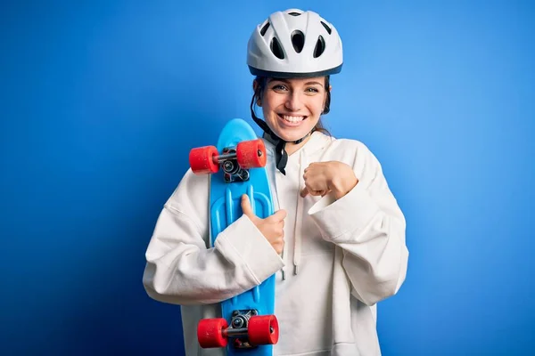 若いです美しいです赤毛スケートボーダー女性身に着けています安全ヘルメット保持スケートで自分自身に指を指して — ストック写真