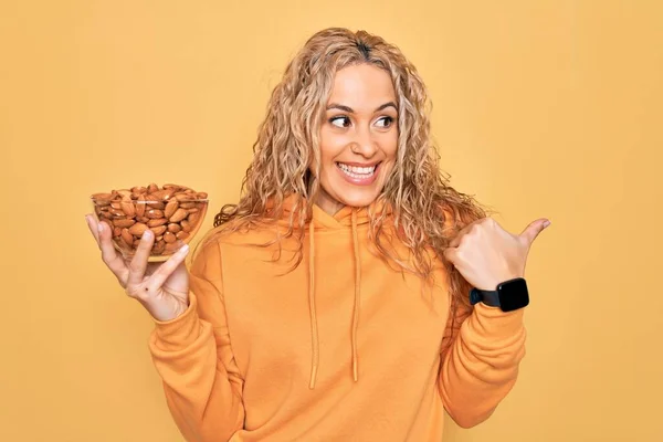 Joven Hermosa Mujer Rubia Sosteniendo Tazón Con Almendras Sanas Sobre — Foto de Stock