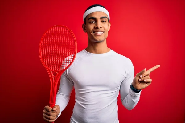 若いですハンサムなアフリカ系アメリカ人スポーツマン遊びテニス使用ラケット以上赤背景非常に幸せなポインティングとともに手と指へザ側 — ストック写真