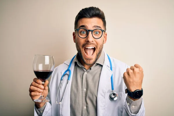若い医者の男を着て聴診器は誇りと勝利と成功を祝う叫んで孤立した背景に新鮮なワインのガラスを飲んで非常に興奮し 感情を応援 — ストック写真