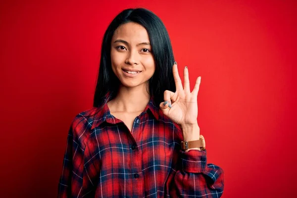 年轻美丽的中国女人穿着休闲装 披着孤立的红色背景 手指头指向三号 面带微笑 自信而快乐 — 图库照片