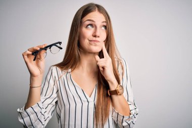 Güzel, kızıl saçlı, gözlüklü, gözlüklü bir kadın. Beyaz arka planda. Ciddi bir yüz.