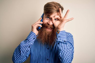 Kızıl saçlı, sakallı İrlandalı bir adam akıllı telefondan konuşuyor. İzole edilmiş bir arka planda, gülen bir yüzle. Tamam imzasını atıyor.