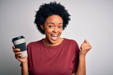Genç Afrikalı afro kadın kıvırcık saçlı bir fincan kahve içen gururlu ve zaferi kutlayan heyecanlı, neşeli duyguları olan