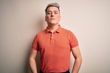 Yüzünde ciddi bir ifadeyle soyutlanmış arka planda duran yakışıklı, modern bir adam. Basit ve doğal bir şekilde kameraya bakıyorsun..