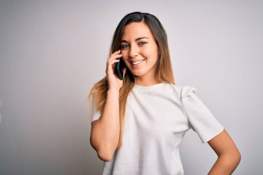 Genç, güzel, esmer bir kadın akıllı telefonda konuşuyor. Mutlu bir yüzü var ve gülümsüyor. Kendine güvenen bir gülümsemeyle dişlerini gösteriyor.