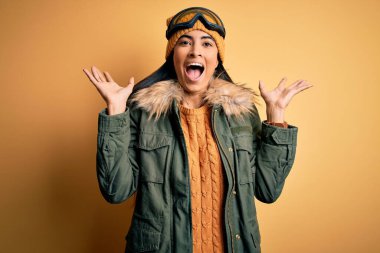 Kış havası için kayak gözlüğü ve palto takan genç ve güzel bir İspanyol kadın çılgınlığı kutluyor ve kollarını kaldırıp heyecanla haykırarak başarıya hayret ediyor. Kazanan konsept