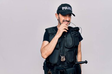 Polis üniforması giyen ve beyaz arka planda kurşun geçirmez yelek giyen orta yaşlı bir polis kameraya kolları çapraz ve çenesi açık bakıyor. Olumlu düşünüyorum..