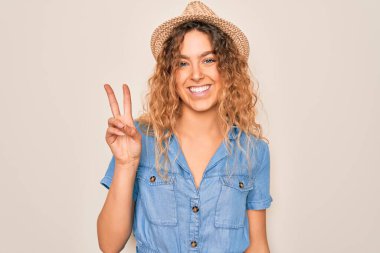 Mavi gözlü, sıradan kot elbiseli ve şapkalı, mutlu yüzüyle kameraya gülümseyen, zafer işareti yapan genç ve güzel bir kadın. İki numara..