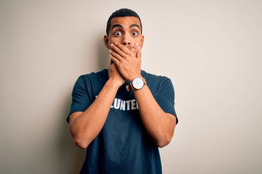Genç, yakışıklı, Afro-Amerikan bir adam gönüllü olarak gönüllü olarak gönüllü olarak tişört giyiyordu. Gönüllü mesajlar içeren bir tişört giyiyordu. Ağzı yanlışlıkla ellerle kapatıyordu. Gizli konsept.