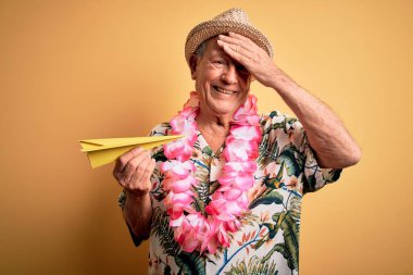 Beyaz saçlı, yaz şapkası takan ve tatilde kağıt uçak tutan Hawaii zambağı takan, utanç ve şaşkınlık dolu, sinirli ve hayal kırıklığına uğramış yaşlı bir adam. Hata için korku ve üzüntü.