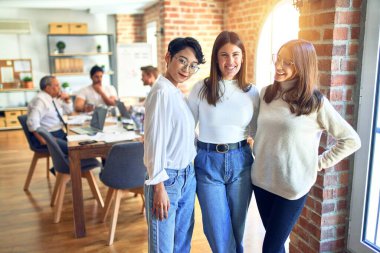 Güzel iş kadınları mutlu gülümsüyor. Yüzünde gülümsemeyle dikilip ofiste dinleniyor.