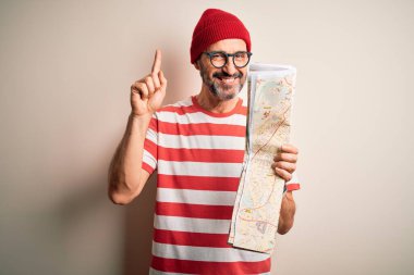 Gözlüklü ve şapka takan orta yaşlı bir adam izole edilmiş beyaz arka plan üzerinde bir fikir ya da soru işareti ile şaşırdı.