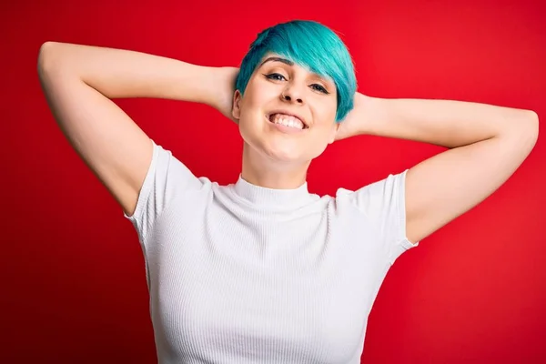 Mavi Saçlı Genç Bir Kadın Kırmızı Arka Planda Rahat Esnek — Stok fotoğraf