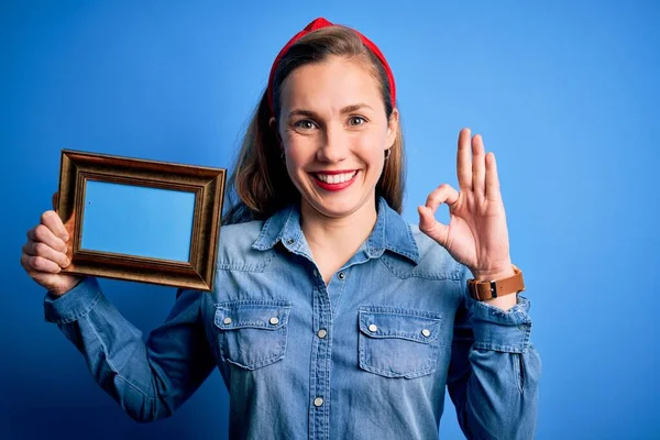 Jovem Mulher Loira Bonita Segurando Moldura Vintage Sobre Fundo Azul — Fotografia de Stock