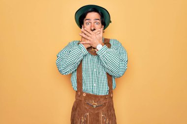 Almanya festivali için geleneksel Alman Ekim Festivali kıyafeti giyen genç yakışıklı adam yanlışlıkla ağızlarını kapatarak şok oldu. Gizli konsept.