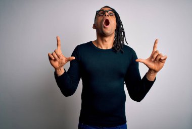 Rastgele tişört giyen, gözlüklü genç ve yakışıklı Afro-Amerikalı adam hayrete düşmüş, şaşırmış ve parmaklarıyla işaret ediyor ve kollarını kaldırıyordu..