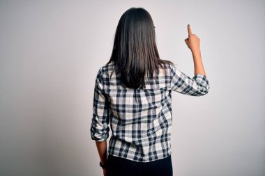 Mavi gözlü genç esmer kadın, beyaz arka planda günlük gömlek ve gözlük takıyor.