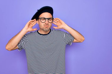 Mor arka planda mavi gözlü, çizgili tişört ve Fransız beresi giyen yakışıklı bir adam iki elini de kulak hareketlerinde, dedikoduya meraklı olarak duymaya çalışıyor. İşitme problemi, sağır