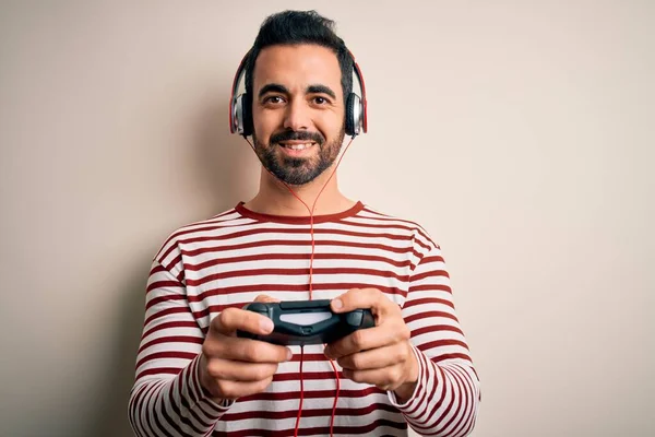 若いですハンサムなゲーマー男ひげ再生ビデオゲームを使用してジョイスティックと幸せな顔立ちと笑顔で自信を持って笑顔歯を示す — ストック写真