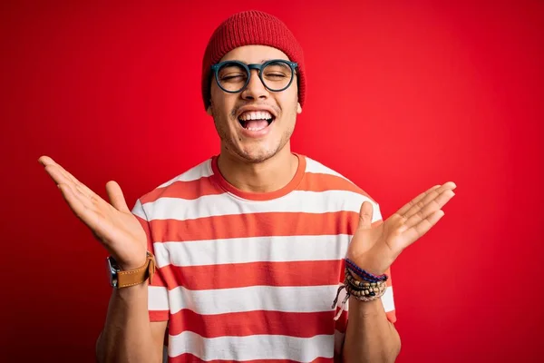 Jovem Brasileiro Vestindo Camiseta Listrada Casual Óculos Sobre Fundo Vermelho — Fotografia de Stock