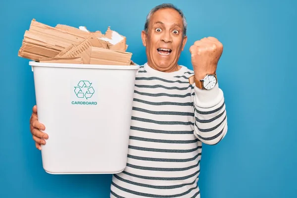 ゴミを持っている高齢者のリサイクルは 誇りと勝利を祝うと非常に興奮し 応援感情を叫んで青色の背景にリサイクルすることができます — ストック写真