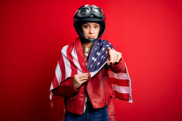 若い美しい愛国的なオートバイの女性は オートバイのヘルメットとアメリカ合衆国のフラグは カメラとあなたに指で指して着て 手のサイン 正とフロントから自信を持ってジェスチャー — ストック写真