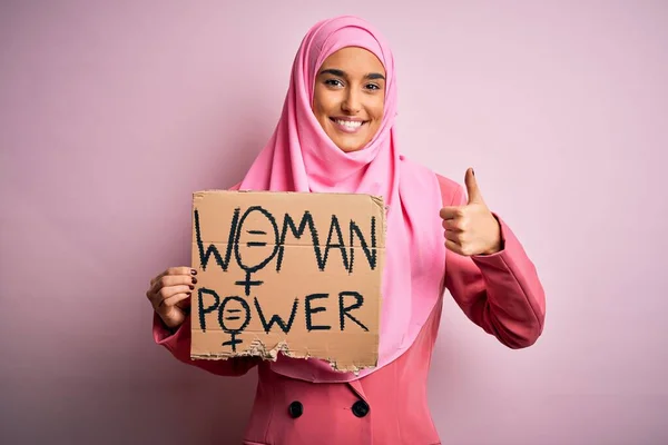 ピンクのイスラム教徒のヒジャーブを身に着けている若い活動家のアラブ女性は 大きな笑顔で幸せパワーメッセージとバナーを保持します — ストック写真