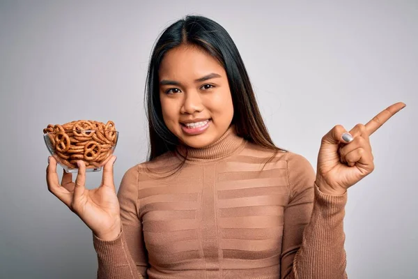 Genç Asyalı Kız Elinde Fırında Alman Krakerleriyle Izole Edilmiş Beyaz — Stok fotoğraf