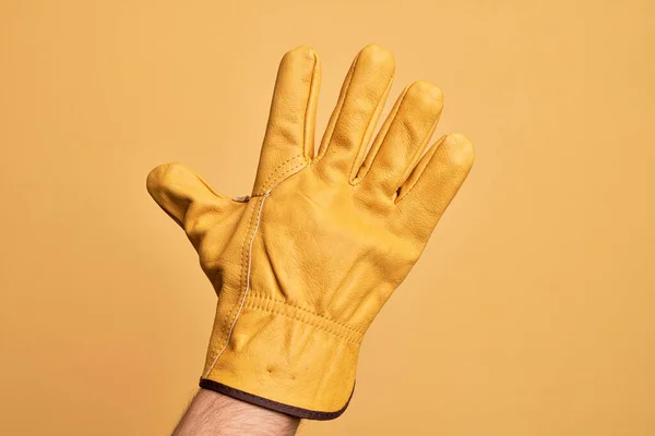 Mão Jovem Caucasiano Com Luva Jardineiro Sobre Fundo Amarelo Isolado — Fotografia de Stock